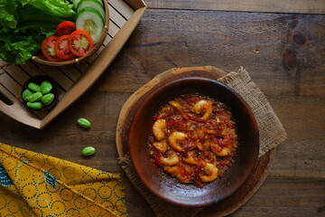 a plate of prawn cooked in sambal in an earhenware plate named gami udang is an Indonesian cuisine from Bontang, Borneo.