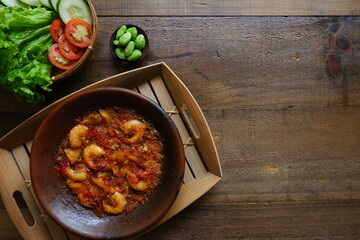 a plate of prawn cooked in sambal in an earhenware plate named gami udang is an Indonesian cuisine from Bontang, Borneo.