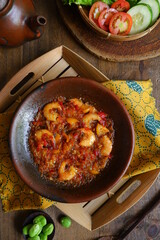 a plate of prawn cooked in sambal in an earhenware plate named gami udang is an Indonesian cuisine from Bontang, Borneo.