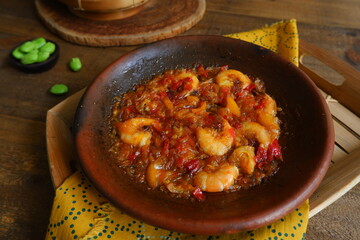 a plate of prawn cooked in sambal in an earhenware plate named gami udang is an Indonesian cuisine from Bontang, Borneo.