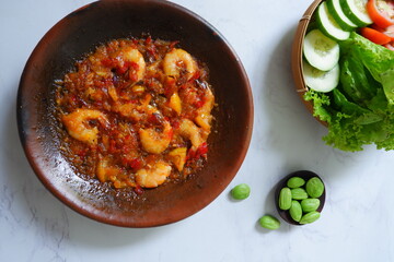 a plate of prawn cooked in sambal in an earhenware plate named gami udang is an Indonesian cuisine from Bontang, Borneo.