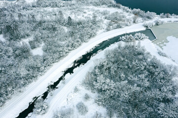 aerial view of frozen river in winter forest with snow-covered trees. winter landscape