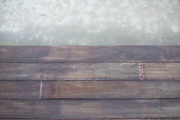 Empty wooden deck with cement background.