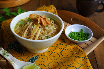 a bowl of Indonesian clear soup named soto Kudus, it contains of rice, vegetables and chicken meat