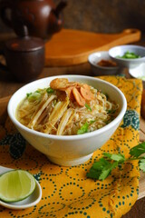 a bowl of Indonesian clear soup named soto Kudus, it contains of rice, vegetables and chicken meat
