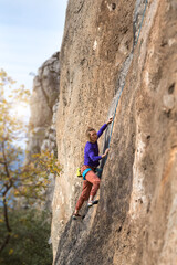 Obraz premium girl climbs a rock-climbing route. outdoor sports.