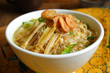 a bowl of Indonesian clear soup named soto Kudus, it contains of rice, vegetables and chicken meat