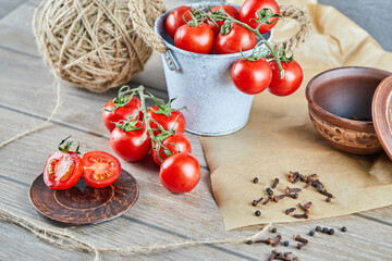 Bucket of tomatoes and half cut tomato on wooden table