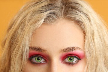 Naklejka premium Young woman with beautiful green eyes on color background, closeup