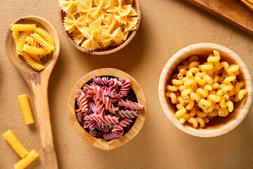 Assortment of dry pasta on color background
