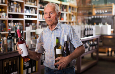 Fine male visiting winehouse in search of bottle of good wine