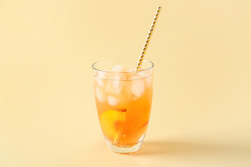 Glass of fruit ice tea on color background