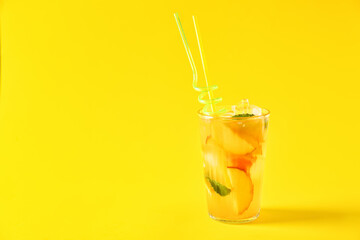 Glass of fruit ice tea on color background