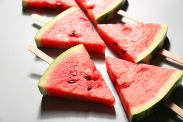 Slices of ripe watermelon with wooden sticks on table