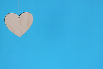 Wooden heart on a blue background. Free space for text.
