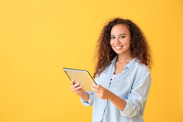 Young woman with tablet computer on color background
