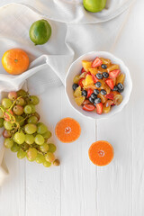 Bowl with fruit salad on light background