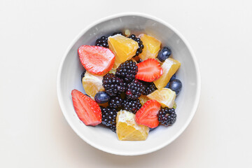 Bowl with fruit salad on white background