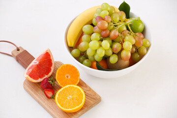 Bowl with different fruits on white background