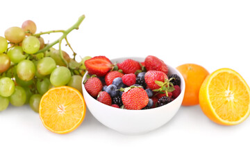 Bowl with different berries and fruits on white background