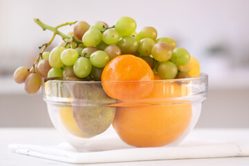 Bowl with different fruits on table