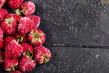 Close up heap of fresh raspberries on dark background