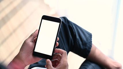 Mockup image of man hands holding mobile phone with blank white screen. Blank screen for advertise text.