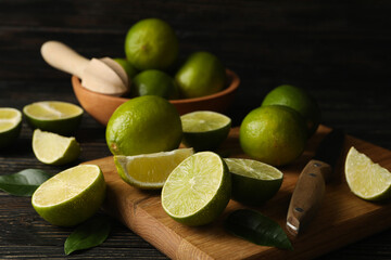 Bowl and board with lime on wooden background