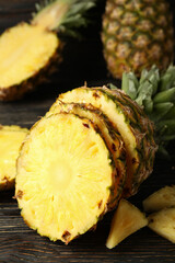 Ripe cutted pineapple on wooden background, close up
