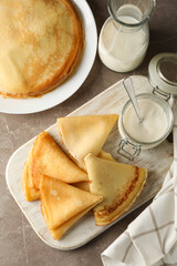 Concept of tasty breakfast with thin pancakes on gray table