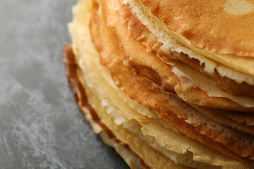 Delicious thin pancakes on black smokey background