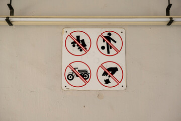Sign on a white painted wall indicating No Skating, No Football, No Motorbikes and No Littering. Stock Photo.
