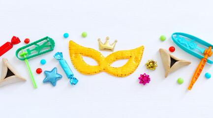 Purim celebration concept (jewish carnival holiday) over wooden white background. Top view, flat lay