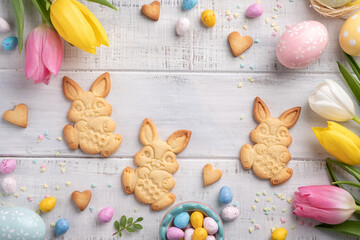Obraz na płótnie Canvas Happy easter background with bunnies, eggs, candies flowers