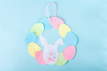 DIY and kids creativity. Step by step instruction: how to make paper easter wreath. Step10 insert pink ribbon into finished wreath. Childrens handmade Easter craft.
