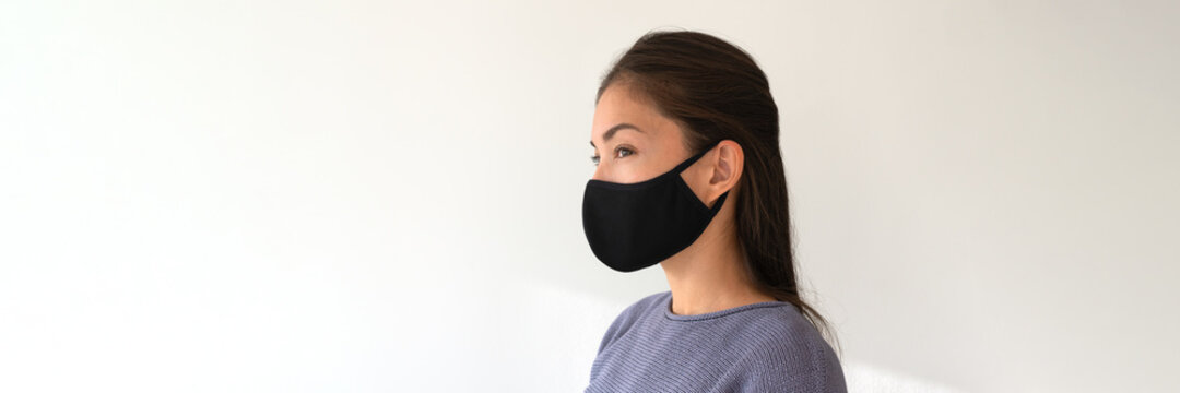 Asian woman wearing black fabric face mask. Casual lifestyle of young people during coronavirus pandemic. Portrait of ethnic girl model with protective facial covering banner.