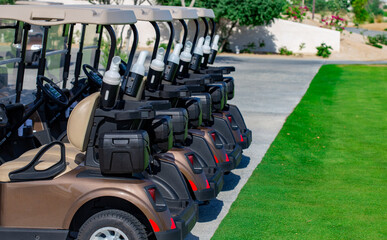 Background image of Golf carts parked on a golf closure in a line.