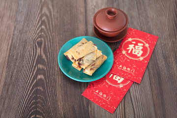 Fried spring rolls, tea and red envelopes on the table at the beginning of spring in Chi