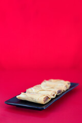 Fried spring rolls, a traditional snack at the beginning of spring on a red background