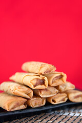 A plate of spring rolls on the red background