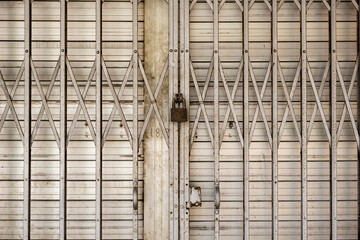 Old, dirty and weathered metal shutters and metal gate, with rusty padlock. Shop Closed. Business Closed Down. Stock Photo.