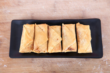 Overlooking a plate of fried spring rolls on the cutting board