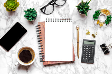 Open blank note book, glasses, cup of coffee, pen, smartphone, succulents on marble table Top view Flat lay Education, goals, resolutions, plans, small owner business concept Home workplace