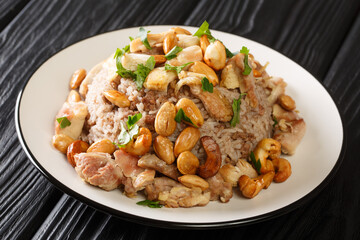Festive Lebanese dish Riz bi-Djaj rice with cinnamon, chicken and nuts close-up in a plate on the table. horizontal