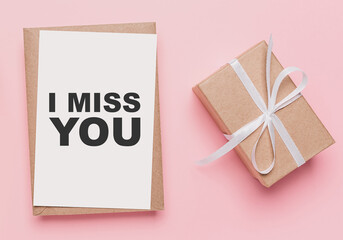 Gifts with note letter on isolated pink background, love and valentine concept with text I miss you