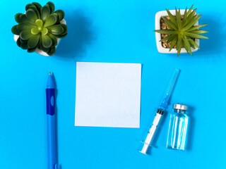 Vaccination concept. Close up view photo of empty sheet of paper for your text, ble pan, syringe,...