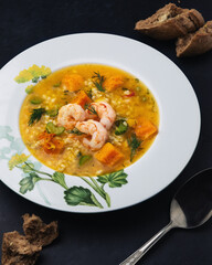 Pumpkin soup with bulgur, shrimp, celery and dill. Rye baguette seasoned with garlic.