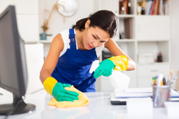 Female cleaner working productively on task in office