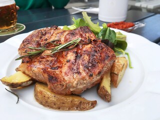 Grilled steaks, baked potatoes. herbs and vegetables,Prague.