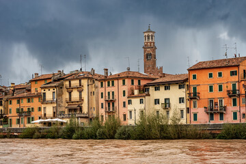 Fototapeta na wymiar The River Adige in flood in Verona downtown after several violent storms. In the background the Lamberti Tower (Torre dei Lamberti, XI century-1403). UNESCO heritage site, Veneto, Italy, Europe.